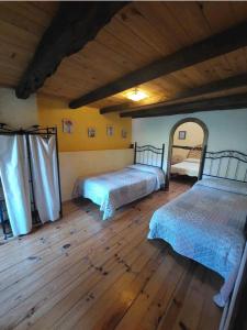 AlmirueteLas Peonías Casa Rural的一间卧室设有两张床,铺有木地板