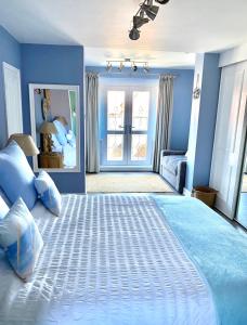 斯凯格内斯Sea Breeze Apartment Skegness的一间卧室配有一张带蓝色墙壁的大床