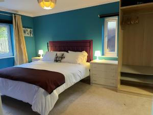 BlaydonBeautiful 2 Bed Apt with Hot Tub in Blaydon Burn的一间蓝色卧室,配有床和2个窗户