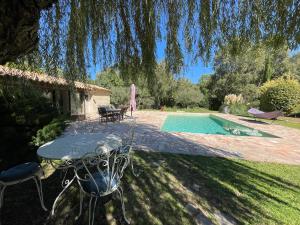 弗维沃FUVOLEA, Maison de vacances à 15 min du centre d'Aix-en-Provence, piscine chauffée en saison - jardin - parking privé gratuit的游泳池旁带桌椅的天井