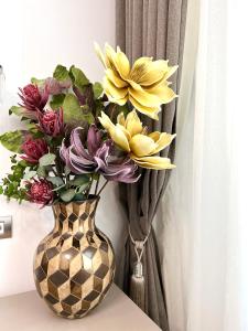 布加勒斯特Sky View - Luxury Apartament - Sanador Victoriei的花瓶,花朵放在桌子上