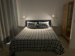 塞维利亚MonKeys Apartments Pagés del Corro Triana的一间卧室配有一张带 ⁇ 子毯子的床
