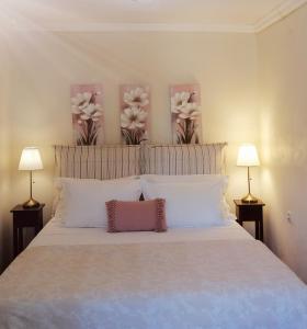 SpartýlasLorantina House_ Holidays in Corfu的一张带白色枕头和鲜花的床铺