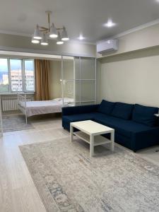 阿拉木图Апартаменты на Назарбаева的客厅配有蓝色的沙发和桌子