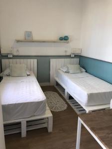 圣保罗Angatu Hostel的带桌子的客房内的两张单人床