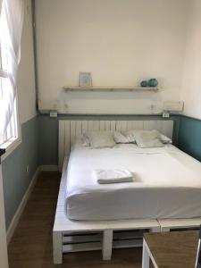圣保罗Angatu Hostel的白色床罩的房间里的一个床位