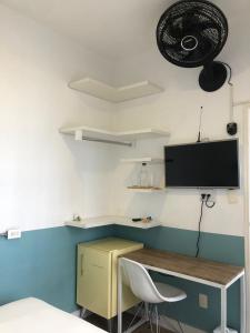 圣保罗Angatu Hostel的客房设有书桌和墙上的电视