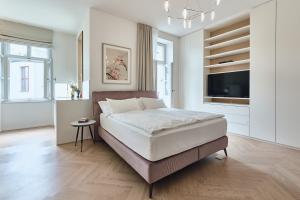 布拉格高处天堂公寓的一间卧室配有一张大床和一台平面电视