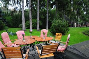 波兰尼卡-兹德鲁伊Pensjonat Willa w Parku的庭院里摆放着木桌和鲜花椅