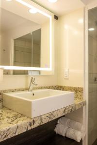 帕拉马里博皇家托拉里卡酒店的浴室设有白色水槽和镜子