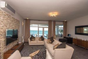 MkunguniZanzibar DT Beachfront Villa的客厅配有2张白色沙发和1台电视