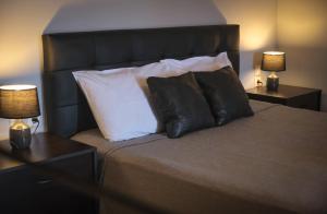凯瑟拉Vretti's apartment的一间卧室配有一张带枕头的床和两盏灯。
