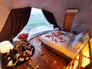 姆茨赫塔Jewelberry Glamping Hotel Tbilisi的卧室配有一张带鲜花的床,位于地板上