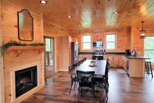 瓦尔登克里克Woodland Cove的小木屋内的厨房和带壁炉的用餐室