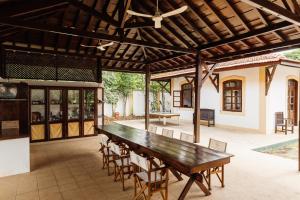 圣多美Roça Vale dos Prazeres的户外庭院配有木桌和椅子