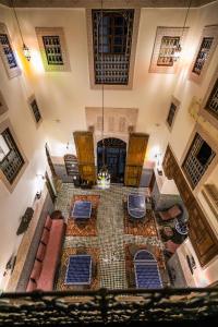 非斯里亚德菲斯艾莎酒店的享有带蓝色椅子的客厅和地板的顶部景色。