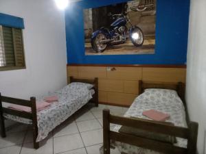 多拉杜斯RECANTO DO ALVORADA的墙上有摩托车的房间里,有两张床