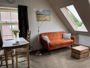 东卡佩勒Gastenverblijf Neeltje的客厅配有橙色沙发和桌子