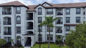 奥兰多Vista Cay Resort的公寓大楼前方有棕榈树