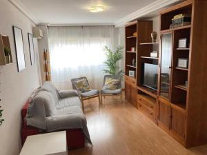 马德里Apartamento grande, 2 dormitorios, garaje gratis的客厅配有两把椅子和电视