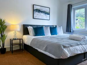 CranfordMaberic Housing的一间卧室配有一张带蓝色和白色枕头的床