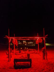 梅尔祖卡Sahara Majestic Luxury Camp的海滩上的一个红色灯饰结构