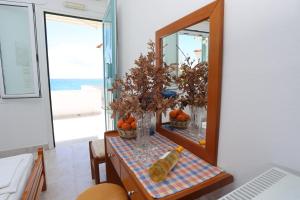 普洛马里翁阿库拉奥吉利酒店的一张桌子,上面有镜子和花瓶,上面有橙子