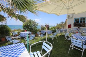 普洛马里翁阿库拉奥吉利酒店的一组桌子和椅子,背景是海洋