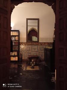 塞拉Riad Dar Badiaa的一个带镜子和书籍的房间的拱门