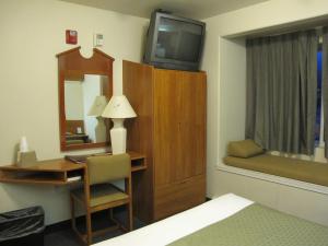 Eagle River伊格尔里弗米克罗特尔酒店的客房设有书桌、电视和床。