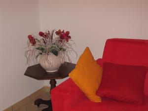 StronconeLa Casetta Arancione appartamento的红沙发旁边的桌子上花瓶
