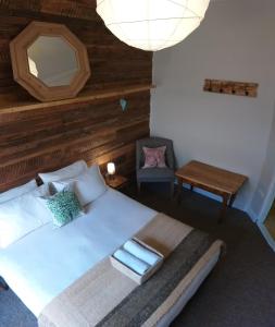 纳塔列斯港Treehouse Patagonia的一间卧室配有一张带镜子和椅子的床