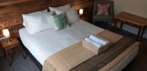 纳塔列斯港Treehouse Patagonia的一张带两个枕头的床和一把椅子