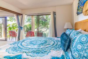 唯客乐渡假村Hale Honu的一间卧室配有一张带蓝色和白色床单的床。