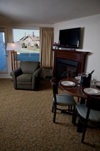 纽波特Oceancliff I & II, a VRI resort的客厅设有壁炉、桌子和椅子