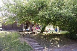 罗托鲁瓦罗托鲁阿温泉假日公园酒店的小木屋,有坐在门廊上树下的人