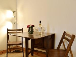 阿伯劳尔Spey Cottage的一张桌子,上面放着两杯酒和一瓶葡萄酒