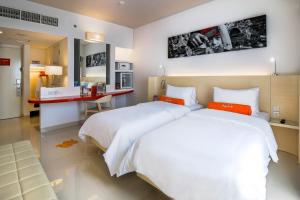 登巴萨登巴萨哈里斯酒店的一间卧室配有两张床和一张书桌