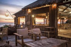 富国芒果湾度假村的海滩上的餐厅,配有桌椅