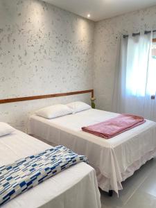 普拉杜Casa de praia Prado Ba Doces magnólias的一间卧室设有两张床和窗户。