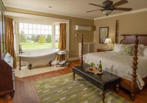 夸利库姆海滩皇冠庄园精品别墅酒店的卧室配有床、浴缸和窗户。