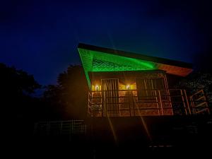 CavintiCaliraya Ecoville Recreation and Farm Resort的一座晚上有绿灯的建筑