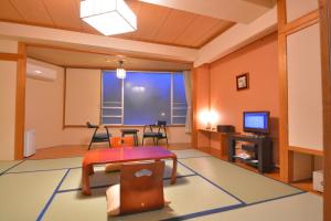 日光日光季之游酒店(Nikko Tokinoyuu)的客厅配有桌子和电视