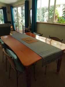 JagganGarden Studio的一张木桌,房间周围摆放着椅子