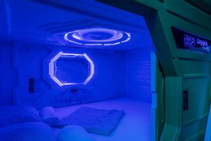 马德里OXYGEN HOSTEL Capsula的一间设有两张床和蓝色灯光的房间