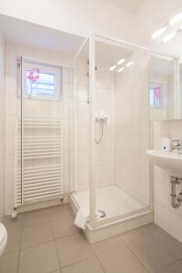 杜塞尔多夫赫尔佐格酒店的带淋浴和盥洗盆的白色浴室