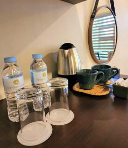 宿务Cebu Quincentennial Hotel的木桌上两瓶水和杯子