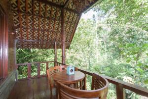 德格拉朗Bali Jungle Resort的小屋门廊上的桌椅