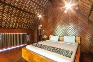 德格拉朗Bali Jungle Resort的一间卧室设有一张床和木墙