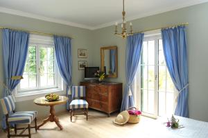 沃尔特湖畔佩莎赫斯赫洛里恩斯丁酒店的一间卧室配有蓝色窗帘、桌子和镜子